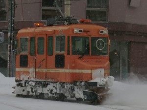 資正館小学校前の交差点を右折するササラ電車（雪11）。
